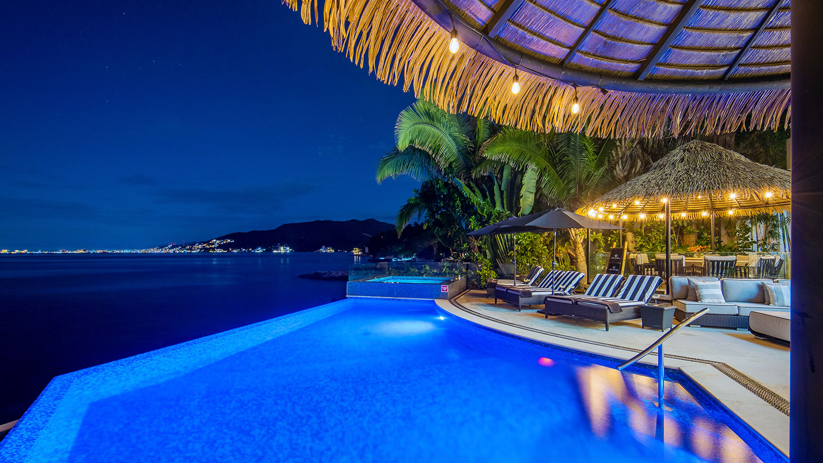 The pool of Casa Damae at dusk, a rental villa on the south shore of Puerto Vallarta, overlooking Banderas Bay