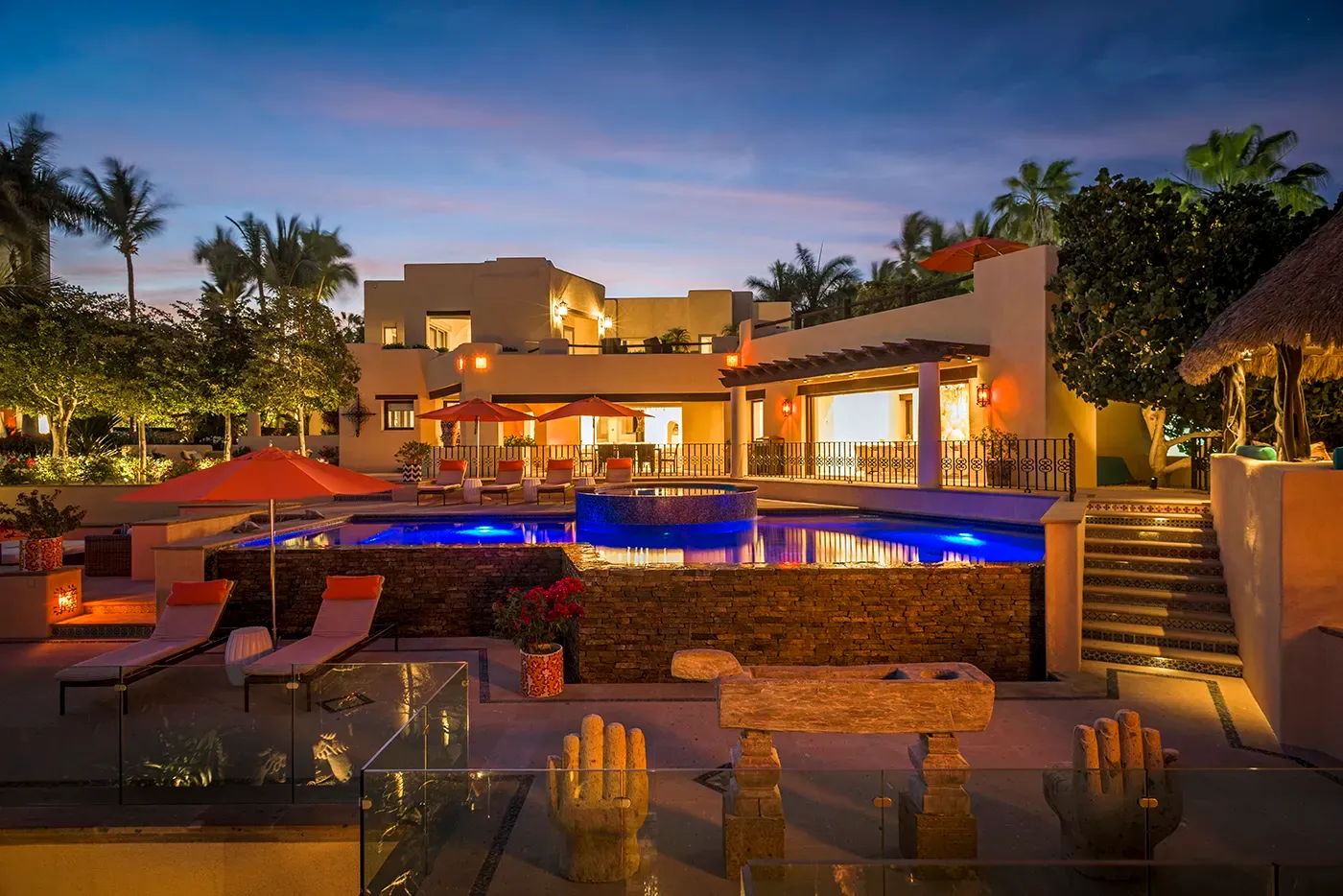 Terraces and pools lit at dusk at Casa Hidalgo, a beachfront rental estate on the Los Cabos Corridor