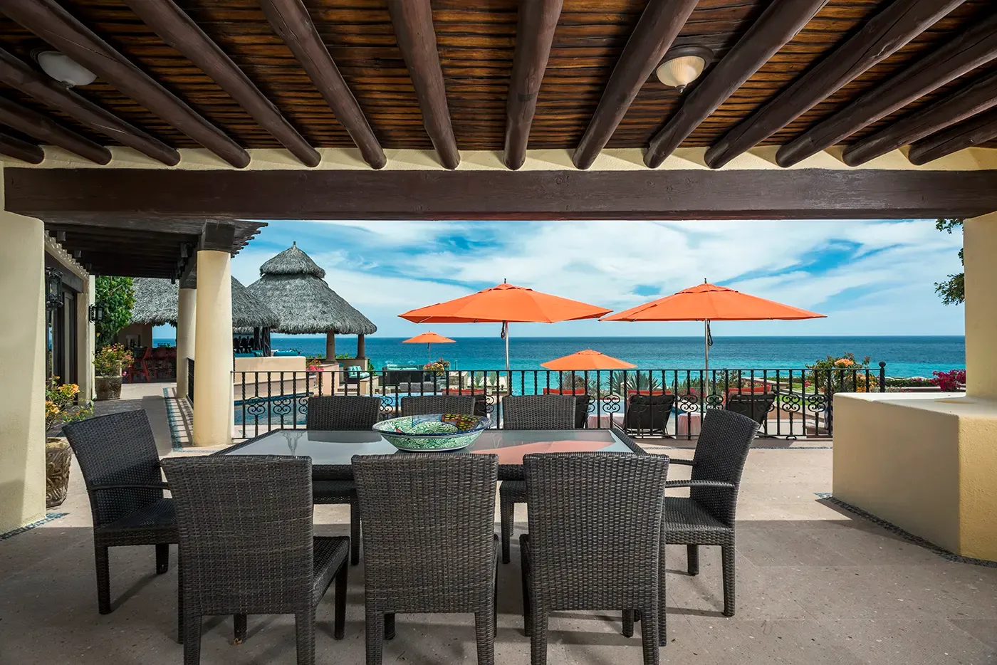 An outdoor dining table set for a group on a shaded terrace at Casa Hidalgo, a rental estate on the Los Cabos Corridor