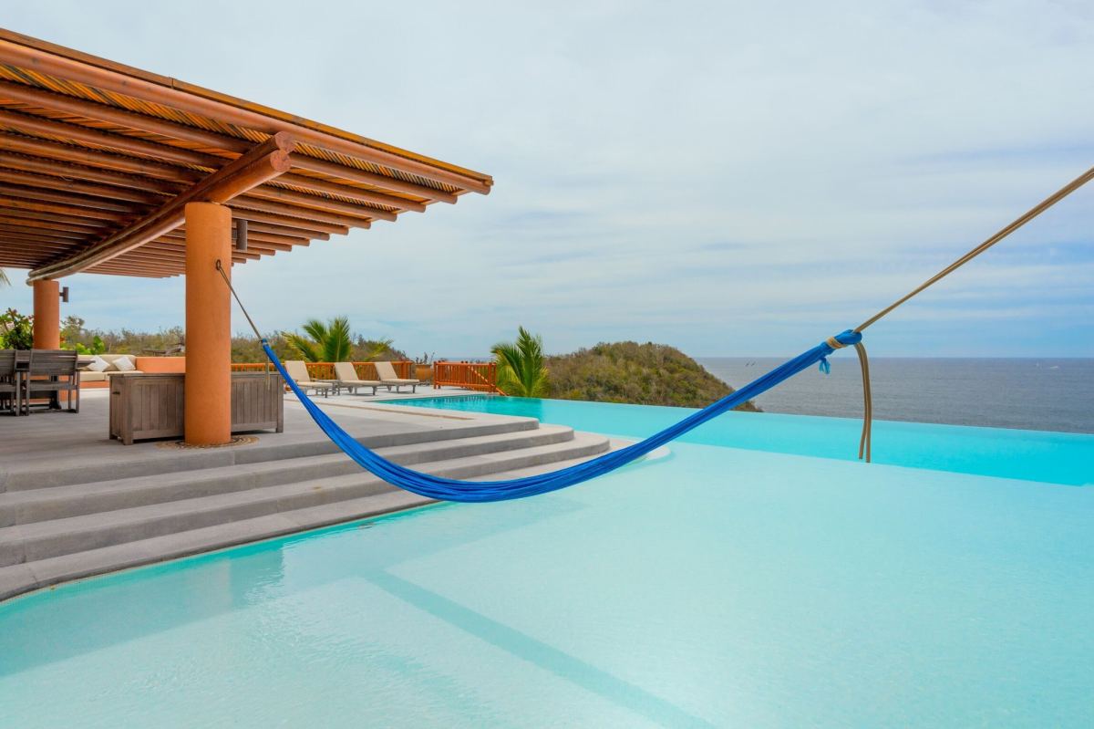 The pool, palapa and hammock at Casa La Ceiba, a rental estate for groups in Costa Careyes