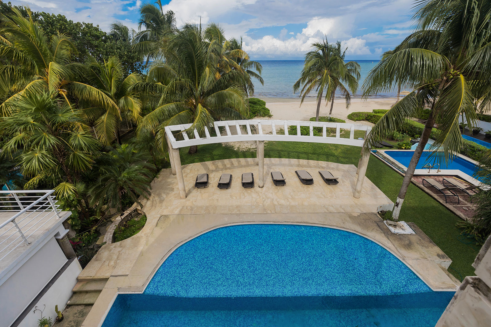 The pool terrace of Casa Santa Pilar Estate, an oceanfront rental villa in Cozumel, facing the Caribbean