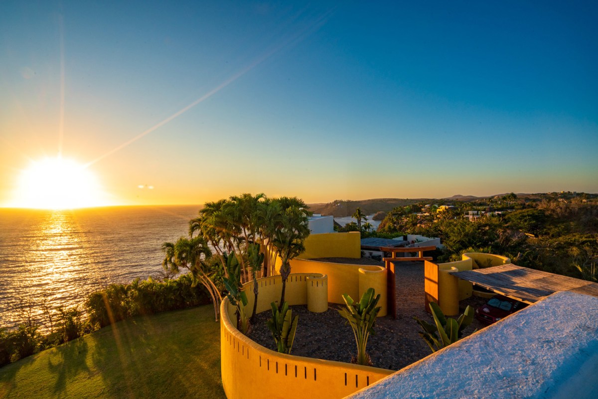 Sunset over the Pacific from the terrace of Casa Sol de Oriente, a cliffside rental estate in Costa Careyes on the Costalegre