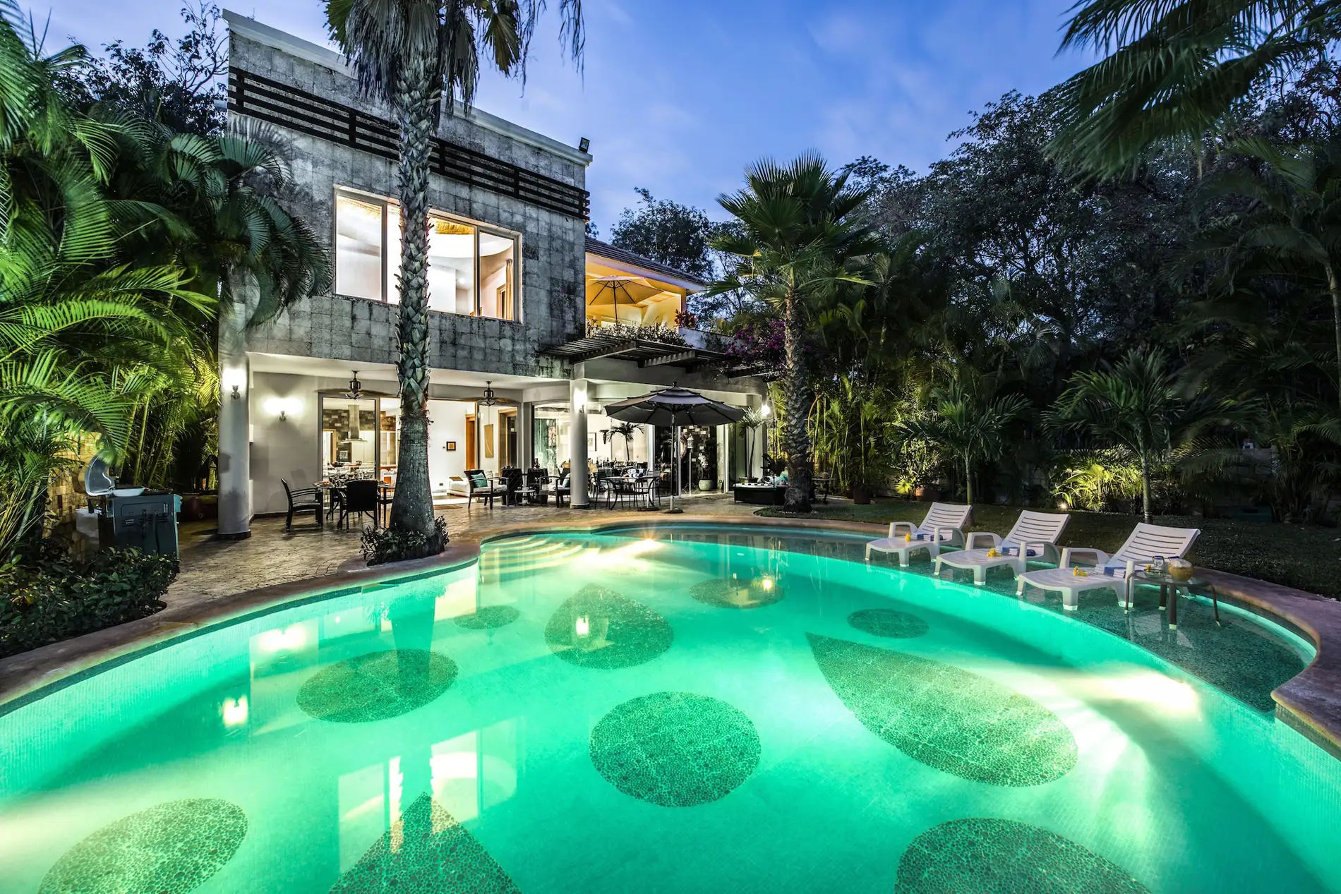 The pool at Casa Caterina, a rental villa in Playacar Phase 1, Playa del Carmen, lit in the evening